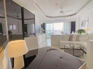 a living room with a couch and a table at Beautiful Sea View Cozy Condo in Pattaya South