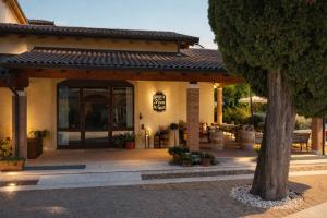 a house with a patio and a tree in front of it at Agriturismo Valentina Cubi in Fumane