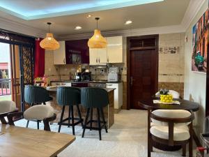 a kitchen with a table and some chairs and a counter at Dina Apartments in Kampala