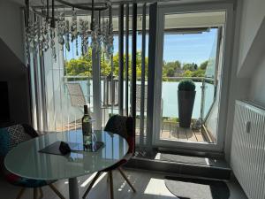 a glass table and chairs in a room with a window at Apartment Orchidee in Mülheim an der Ruhr
