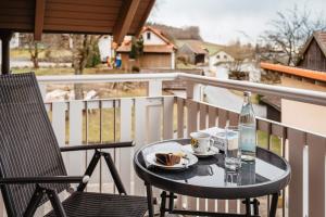 a table with a drink and a plate of food on a balcony at Ferienwohnung Pietzavka in Wiesenfelden