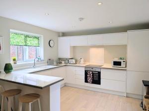 a kitchen with white cabinets and a counter top at The Mews with free parking in York