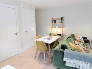 a living room with a green couch and a table at The Mews with free parking in York +28 photos