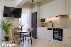 a kitchen with a table and chairs in a room at Zoi Suite - fully renovated luxury apartment in Chalkida