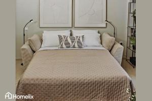 a large bed with pillows on top of it at Zoi Suite - fully renovated luxury apartment in Chalkida