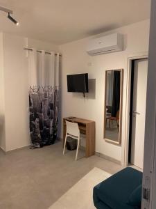 a room with a desk and a tv and a chair at Kennedy rooms in Isernia