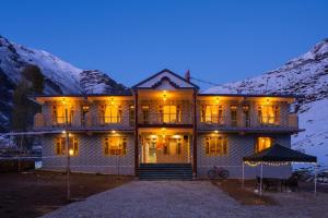 a large house with lights on it in the mountains at PACK Sissu in Sissu