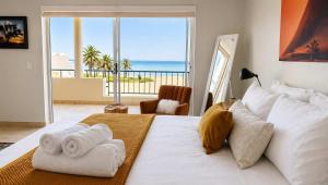 a bedroom with a white bed with a view of the ocean at Sunset View 10 @ Langstrand in Langstrand