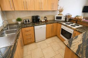 a kitchen with a sink and a stove top oven at Sunset View 10 @ Langstrand in Langstrand