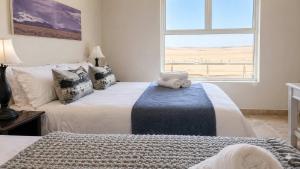 a bedroom with two beds and a window at Sunset View 10 @ Langstrand in Langstrand +18 photos