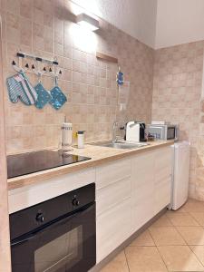 a kitchen with a sink and a microwave at La Piccola Dimora in Giovinazzo +23 photos