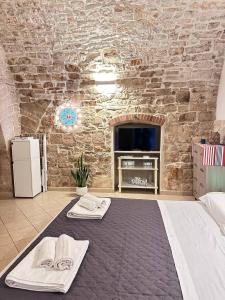 a room with a bed and a brick wall at La Piccola Dimora in Giovinazzo