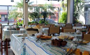 a table with plates of food on it in a restaurant at Hotel Caiçara in Praia Grande
