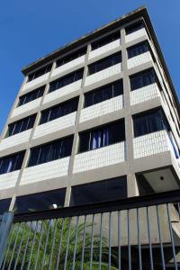 a tall building with a fence in front of it at Hotel Caiçara in Praia Grande
