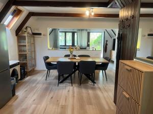 a kitchen and dining room with a table and chairs at LODKA Vendégház in Szigetcsép