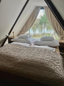 two beds in a room with a window at LODKA Vendégház in Szigetcsép +65 photos