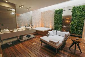 a bathroom with a couch and a tub and a sink at Luna Blu Concept in Curitiba