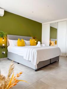 a bedroom with a large bed with yellow pillows at E1 Suites & Spa aparthotel style - Gym & Spa in Gibraltar