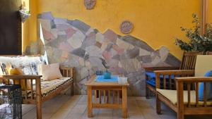 a living room with chairs and a stone wall at Casa Stelle Marine in Palau