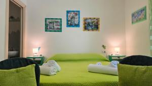 a bedroom with two green beds and two chairs at Casa Stelle Marine in Palau