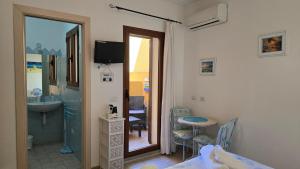 a room with a bed and a sink and a table at Casa Stelle Marine in Palau
