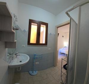 a bathroom with a sink and a window and a bedroom at Casa Stelle Marine in Palau +20 photos