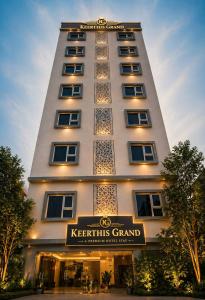 a tall white building with a sign in front of it at Keerthis Grand Hotel near Kempegowda International Airport in Bangalore