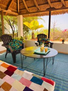 a living room with a coffee table and chairs at Villa Mouna in Poponguine