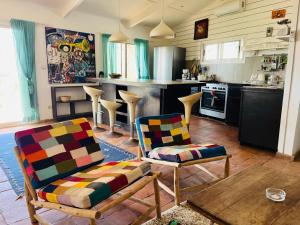 a living room with two chairs and a kitchen at Villa Mouna in Poponguine +14 photos