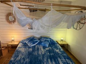 a net hanging over a bed in a room at Villa Mouna in Poponguine