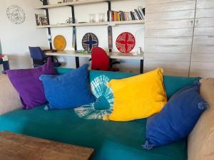 a green couch with colorful pillows on it at Villa Mouna in Poponguine