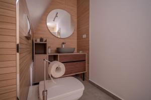 a bathroom with a toilet and a sink and a mirror at Lotus 2 in Goruna +14 photos