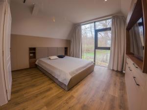 a bedroom with a bed and a large window at Lotus 2 in Goruna