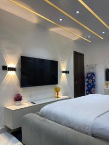 a bedroom with a large bed and a flat screen tv at Meenah luxury homes in Ikeja
