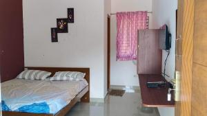 a bedroom with a bed and a television in it at New Mountain Resort in Nāmakkal