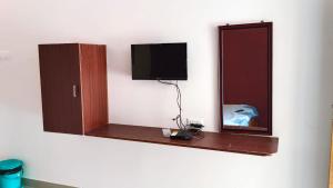 a room with a mirror and a tv on a wall at New Mountain Resort in Nāmakkal
