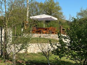 a picnic table with an umbrella in a garden at Aleksa in Cetinje