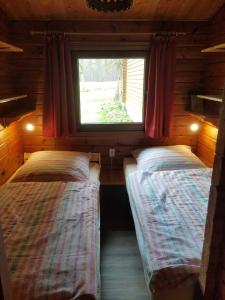 two beds in a small room with a window at Ferienhaus Ostsee in Steinberg