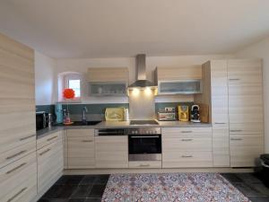 a kitchen with white cabinets and a stove top oven at Ferienwohnung Lachen in Lachen
