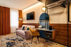 a hotel room with a couch and a desk at voco Budapest D8 by IHG in Budapest