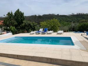 a swimming pool with two lounge chairs at Herdade di Luce SPA in Daporta