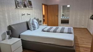 a bedroom with a large bed with striped pillows at Ferienwohnung BungertOase in Saarburg