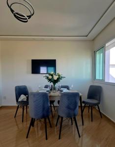a dining room with a table and blue chairs at APPARTEMENT DE LUXE 3 Façades in Ben Slimane