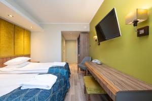 a hotel room with two beds and a flat screen tv at Fra Mare Thalasso Spa in Haapsalu