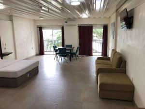 a living room with a couch and a table and chairs at Leuchtturm Resort in Boljoon