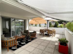 a patio with a table and chairs and an umbrella at Le Clos Brémontier in Soorts-Hossegor