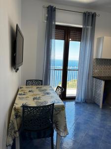 a dining room with a table and a view of the ocean at Luisa apartments, Coastal escape on the Amalfi Coast! in Furore