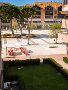 a park with red tables and chairs and a building at CasAmare in Francavilla al Mare
