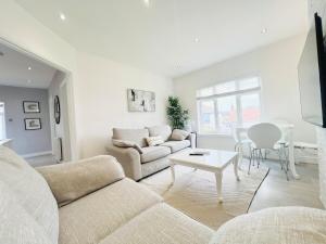 a living room with a couch and a table at Bright 2-Bed Flat - 1 min to Enfield Lock Station in Enfield Lock