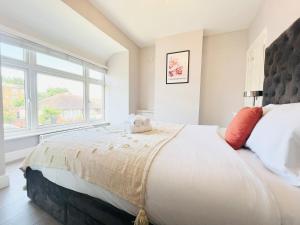 a bedroom with a large bed and a window at Bright 2-Bed Flat - 1 min to Enfield Lock Station in Enfield Lock